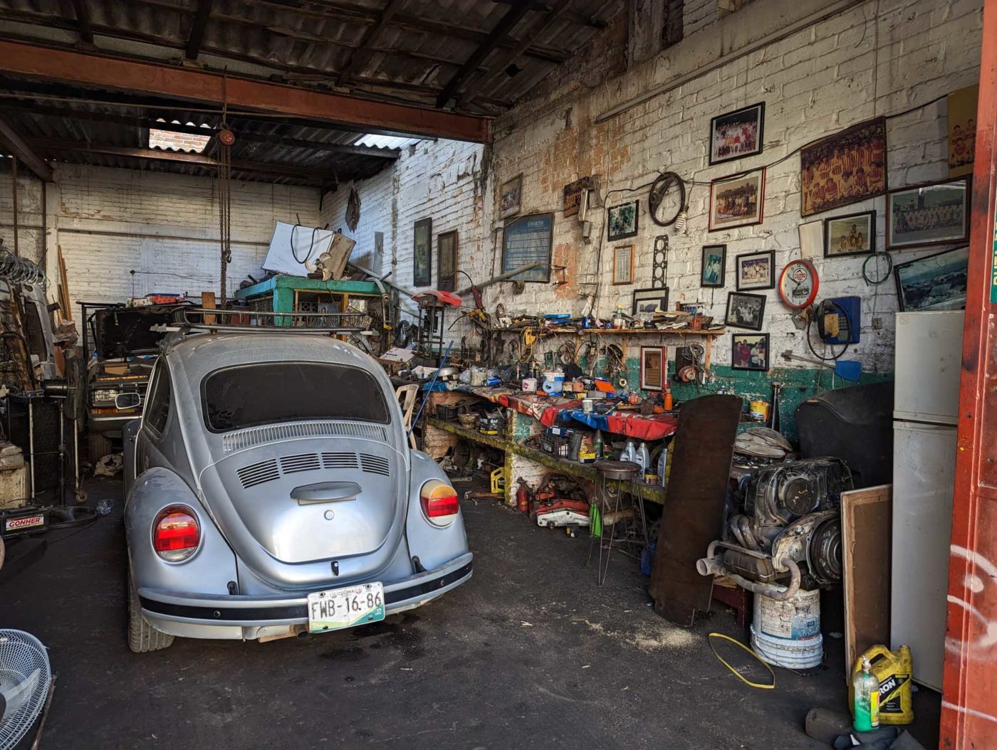 a car parked in a garage next to a wall with pictures on it.