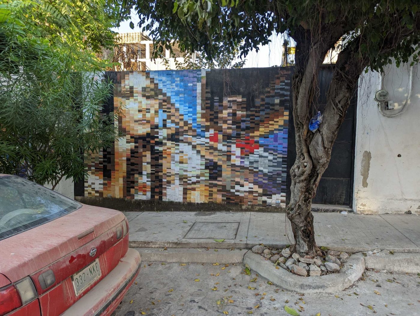 a car parked next to a wall with a painting on it.