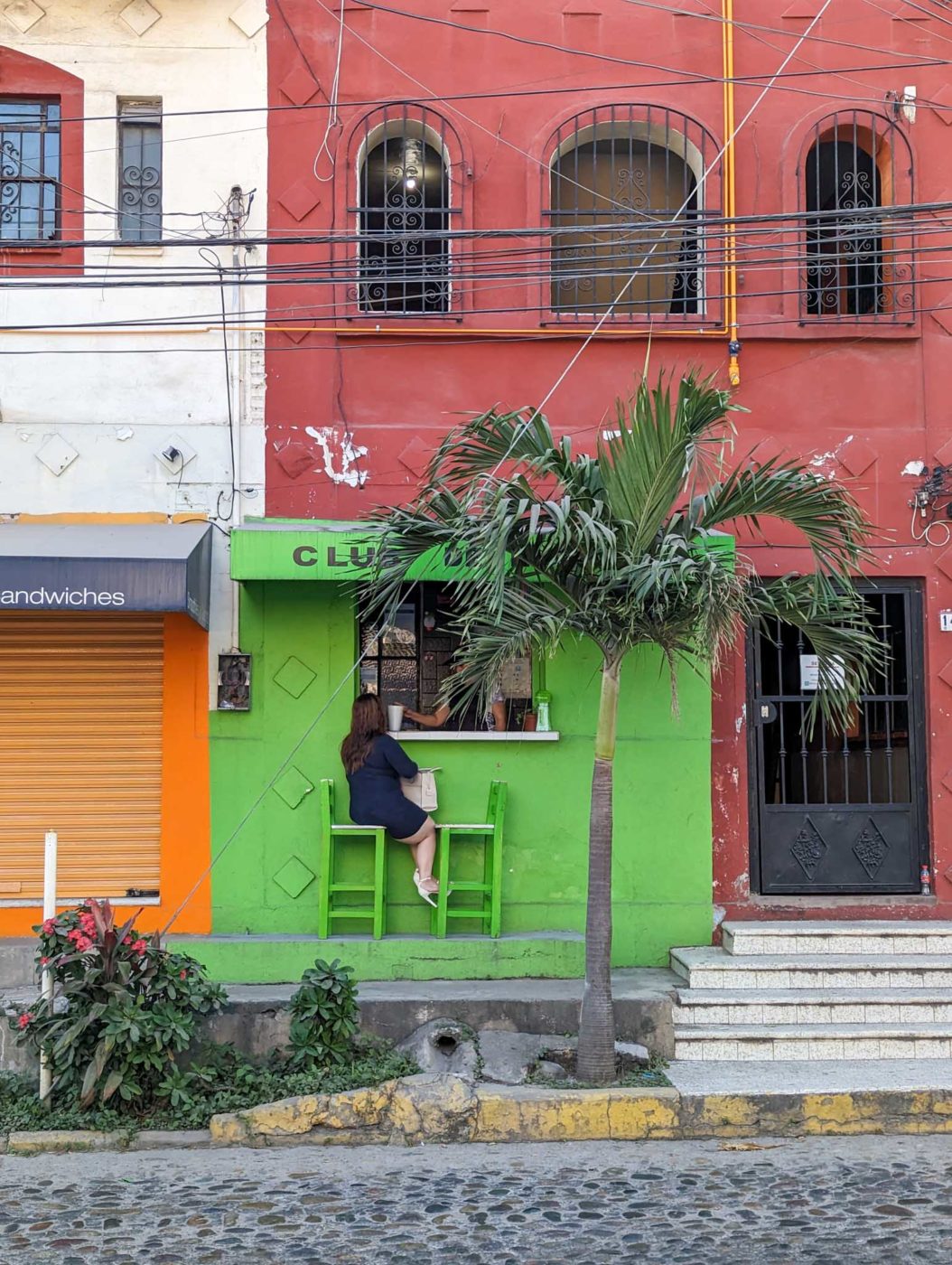 a person sitting at a table in front of a building.