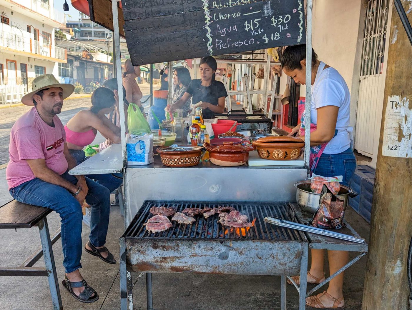 a man and a woman cooking food on a grill.