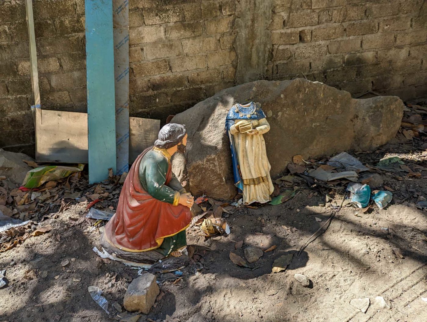 a statue of a person sitting next to a rock.