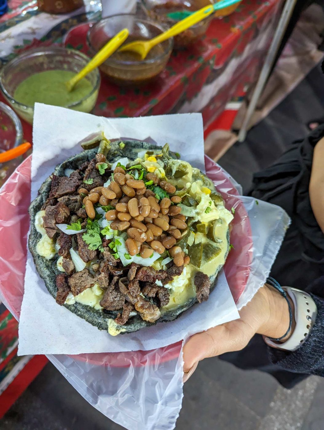 a person holding a plate of food on a table.