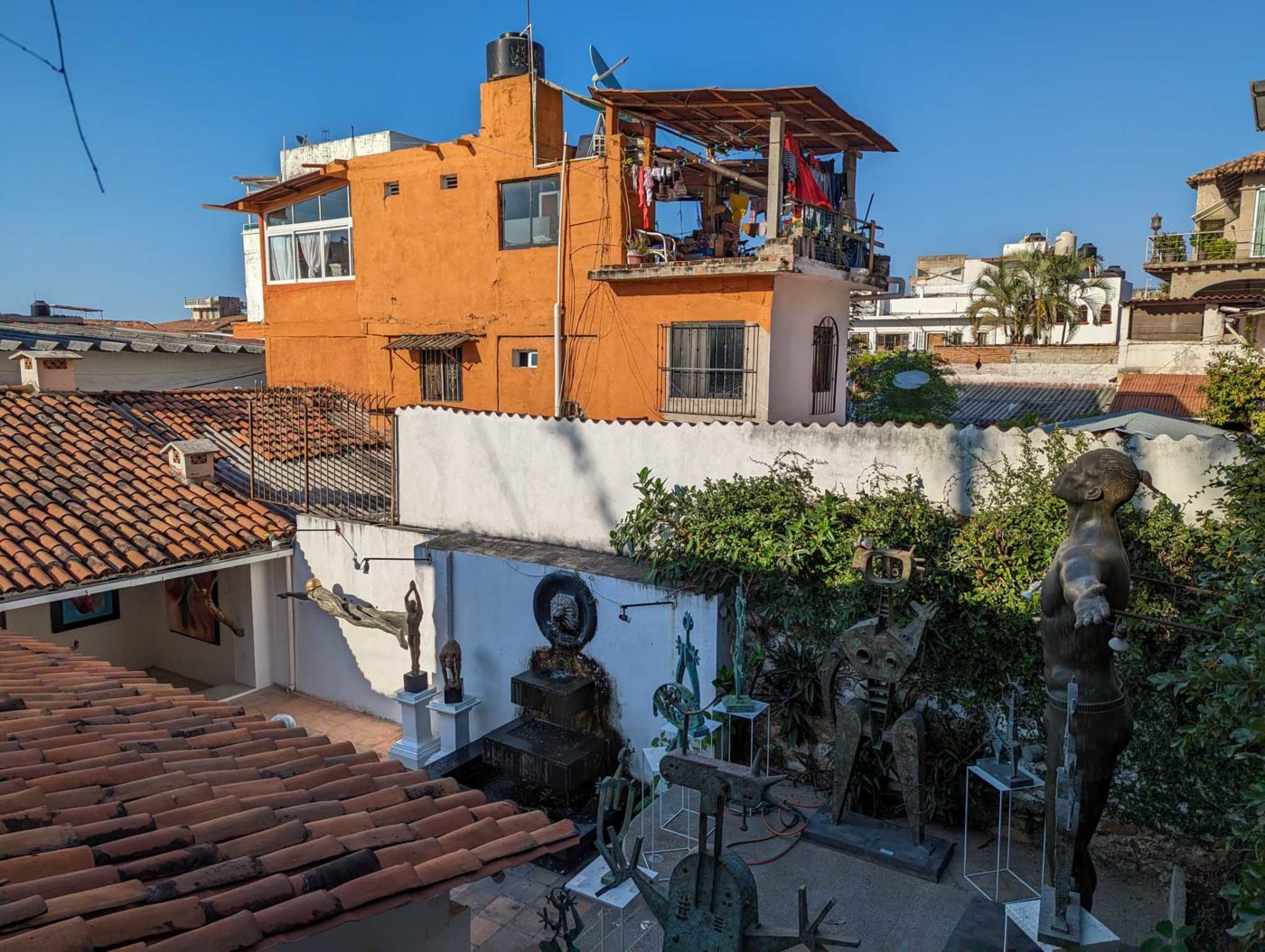 a view of a rooftop with a statue of a man on top of a building.